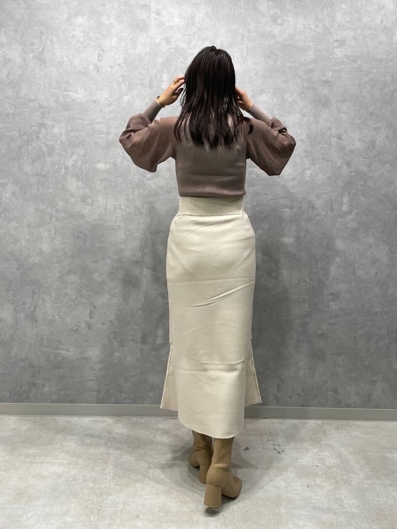 ベージュ系のブーツ、ベージュ系のニット/セーター、ホワイト系のスカートを着用したレディースの秋コーディネートの4枚目の写真