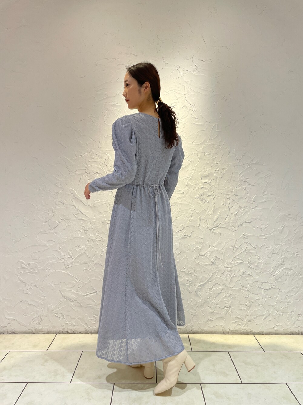 ホワイト系のブーツ、ブルー系のワンピースを着用したレディースの冬コーディネートの7枚目の写真