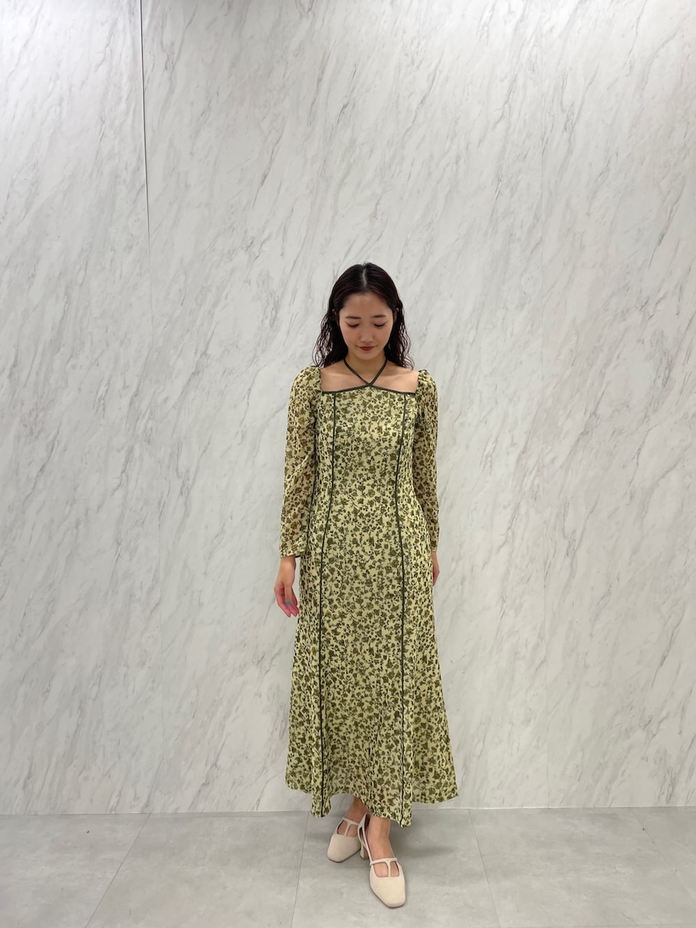 ホワイト系のパンプス、グリーン系のワンピースを着用したレディースの冬コーディネートの2枚目の写真