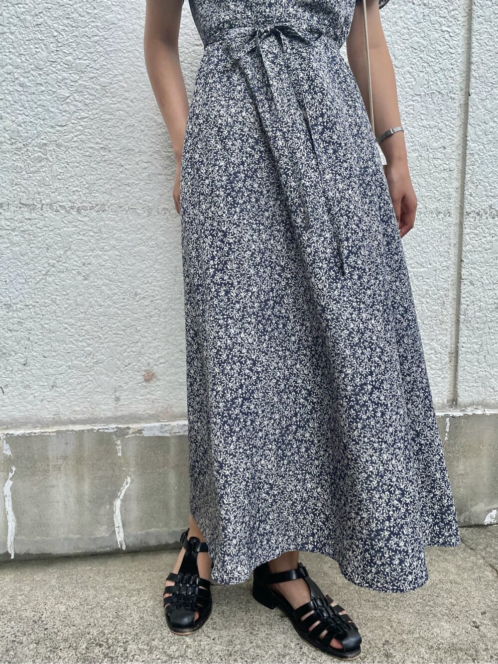 ベージュ系のハンドバッグ、ブルー系のワンピース、ゴールド系のネックレスを着用したレディースの夏コーディネートの7枚目の写真