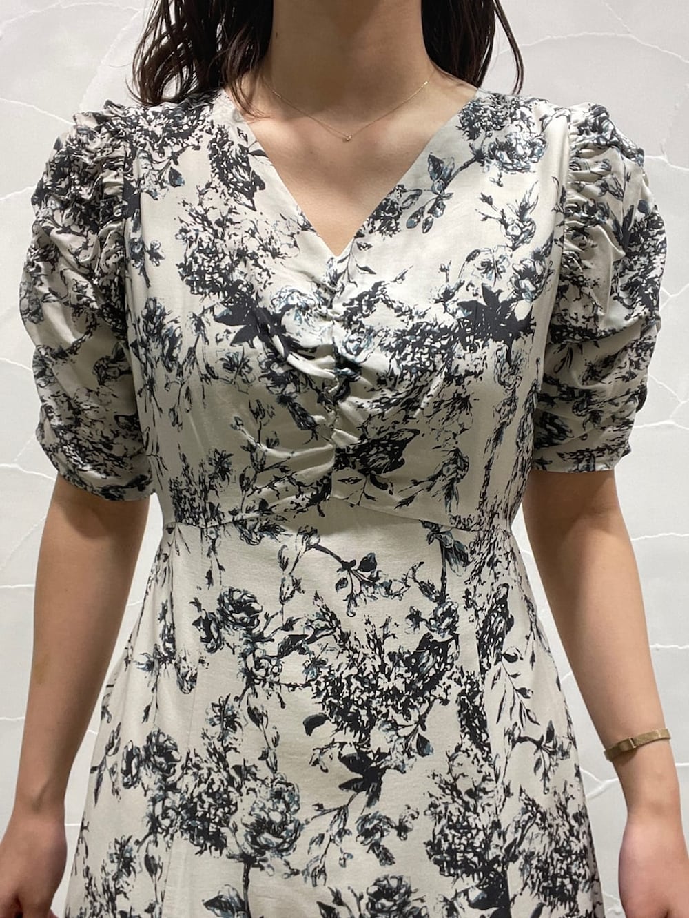 パープル系のテーラードジャケット、ベージュ系のブーツ、グレー系のワンピースを着用したレディースの春コーディネートの9枚目の写真