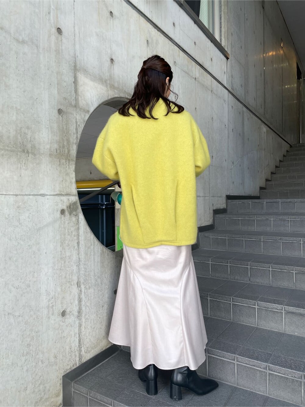 ブラック系のブーツ、イエロー系のカーディガン/ボレロ、グレー系のスカートを着用したレディースの秋コーディネートの4枚目の写真