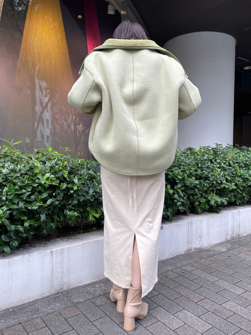 ベージュ系のブーツ、ブラック系のニット/セーター、ホワイト系のスカートを着用したレディースの秋コーディネートの5枚目の写真