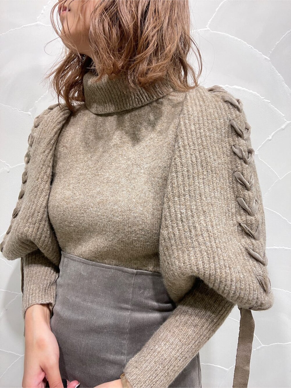 グレー系のスカート、ベージュ系のニット/セーターを着用したレディースの冬コーディネートの4枚目の写真