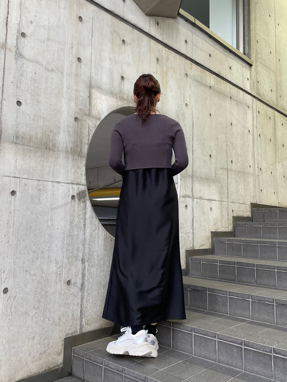 ホワイト系のスニーカー、ブラック系のワンピースを着用したレディースの冬コーディネートの6枚目の写真