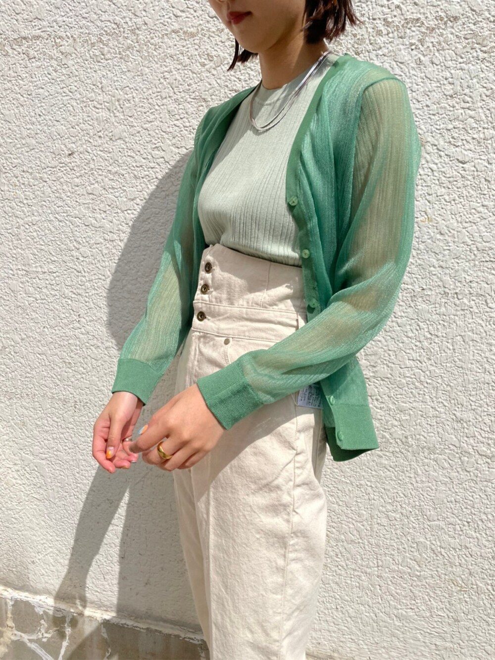 その他のパンプス、ホワイト系のデニムパンツ、グリーン系のニット/セーターを着用したレディースの春コーディネートの2枚目の写真