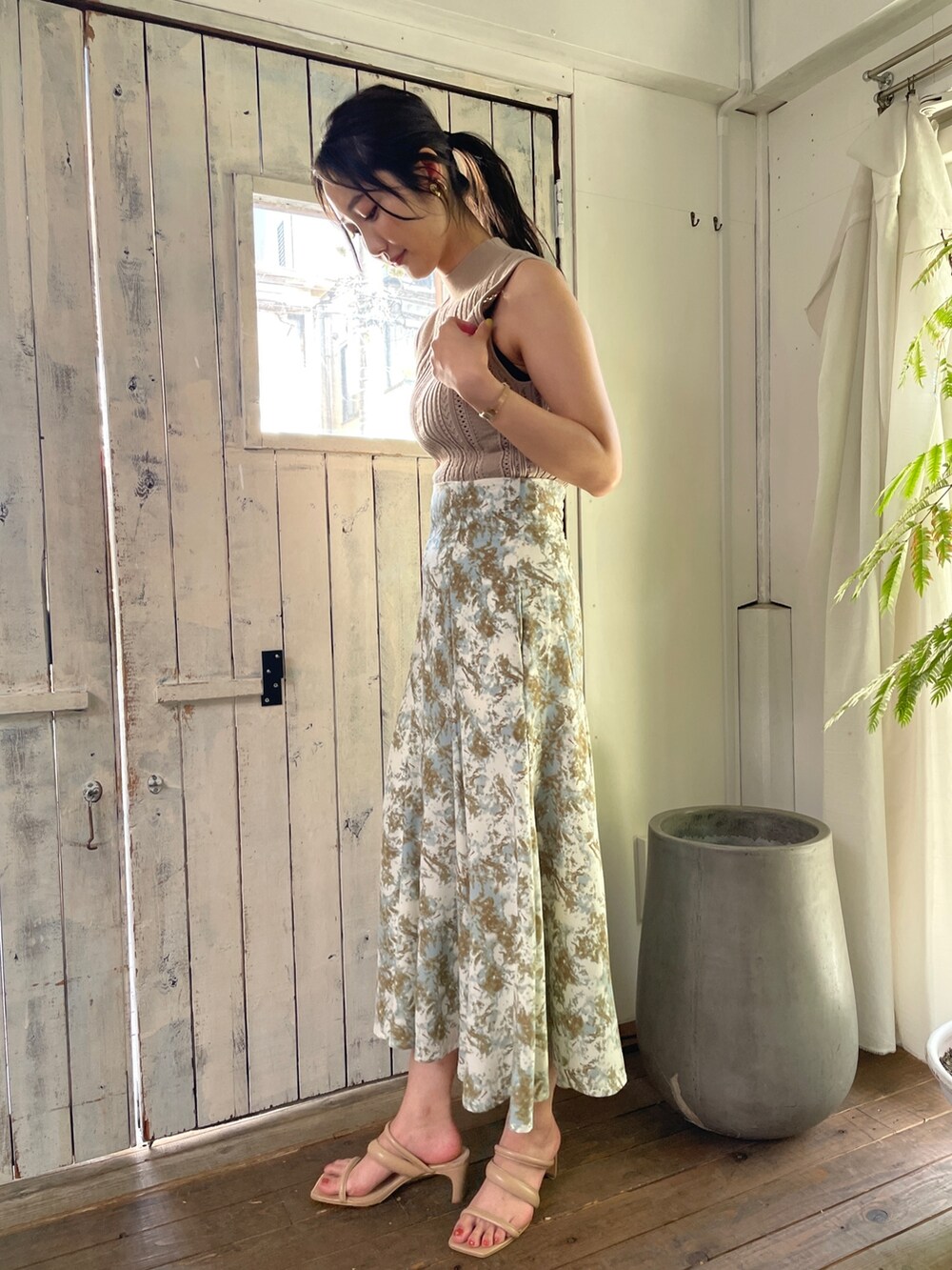 ベージュ系のサンダル、グリーン系のスカート、ベージュ系のニット/セーターを着用したレディースの春コーディネートの4枚目の写真