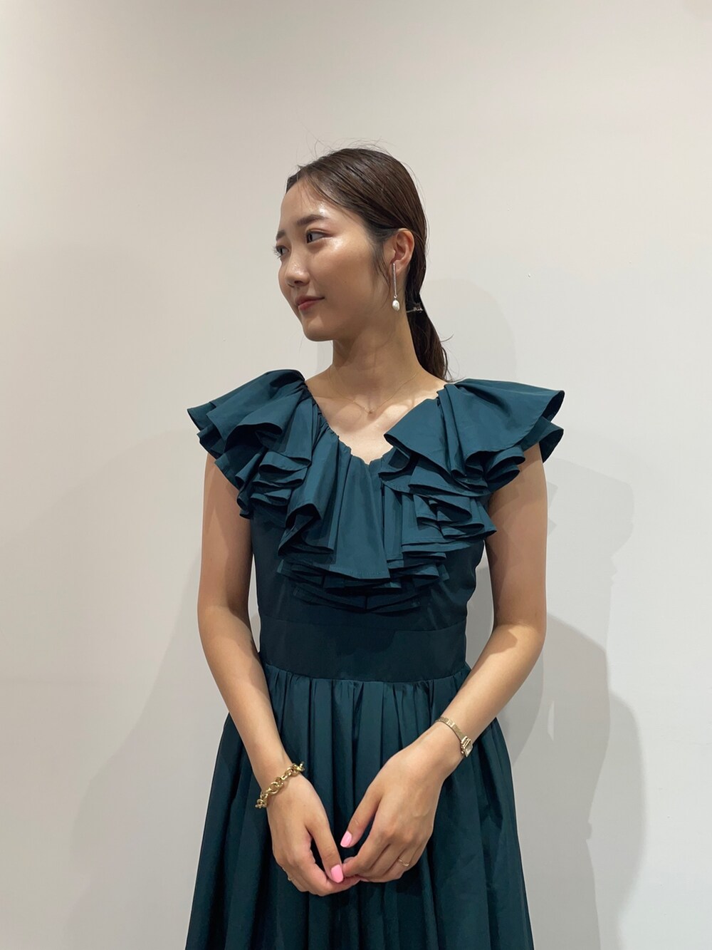 ベージュ系のパンプス、グリーン系のドレス、シルバー系のバレッタ/ヘアクリップを着用したレディースの夏コーディネートの5枚目の写真