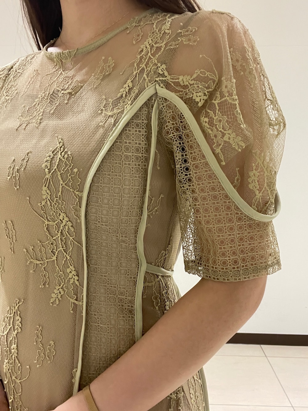 ベージュ系のパンプス、グリーン系のドレスを着用したレディースの春コーディネートの7枚目の写真