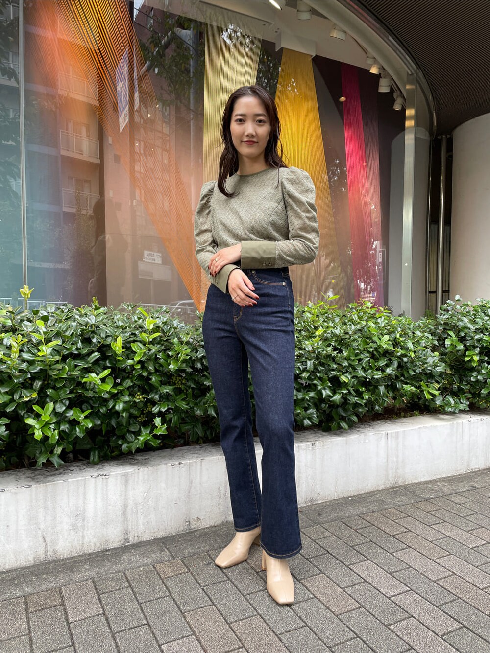 ベージュ系のシャツ/ブラウス、ブラック系のブルゾン、ブルー系のデニムパンツを着用したレディースの秋コーディネートの6枚目の写真