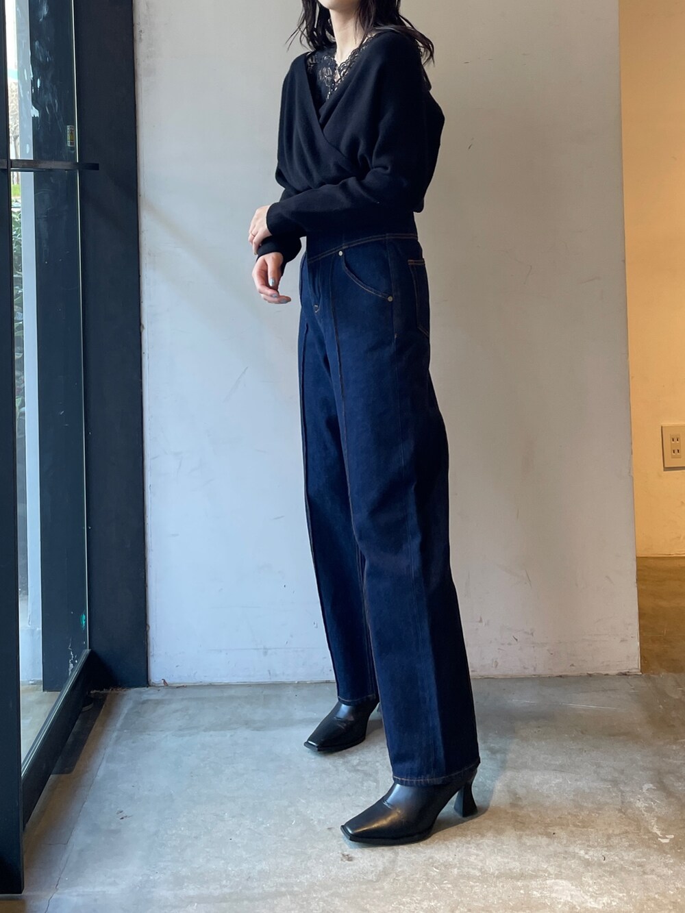 ブラック系のブーツ、ブルー系のデニムパンツ、ブラック系のニット/セーターを着用したレディースの冬コーディネートの3枚目の写真