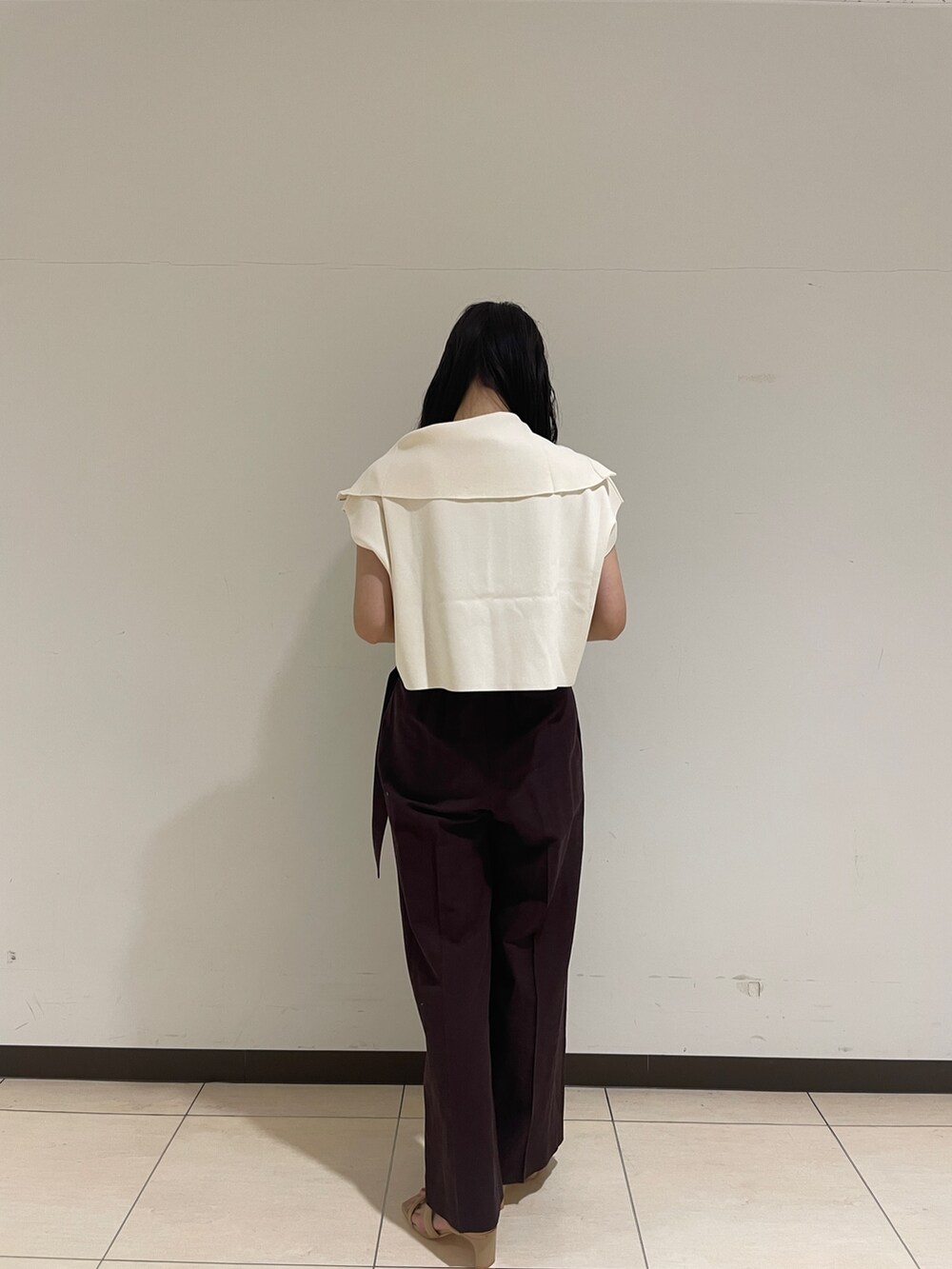 ブラウン系のその他パンツ、ホワイト系のニット/セーター、ベージュ系のサンダルを着用したレディースの春コーディネートの6枚目の写真