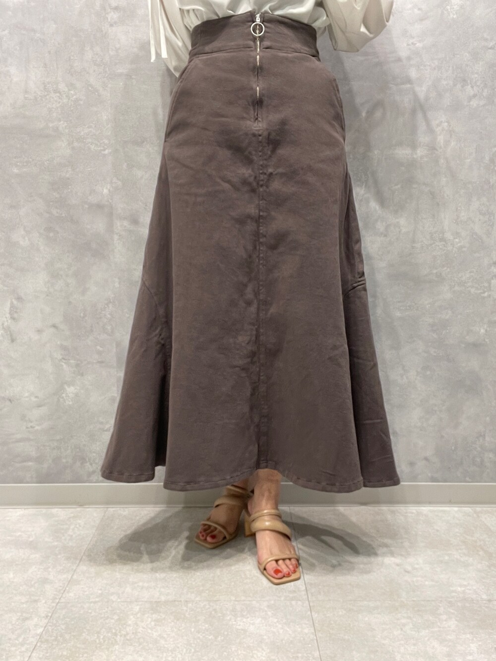 ベージュ系のサンダル、グレー系のスカート、グレー系のテーラードジャケットを着用したレディースの春コーディネートの8枚目の写真