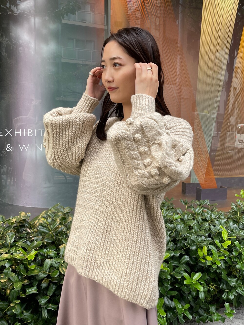 ホワイト系のニット/セーター、ホワイト系のその他アウター、ベージュ系のスカートを着用したレディースの秋コーディネートの7枚目の写真