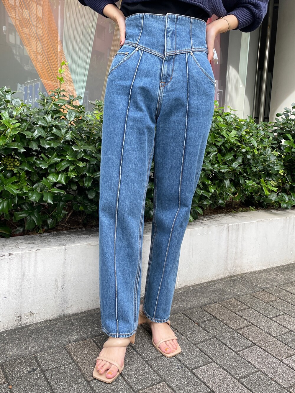 ベージュ系のサンダル、ブルー系のデニムパンツ、ブラック系のニット/セーターを着用したレディースの冬コーディネートの5枚目の写真