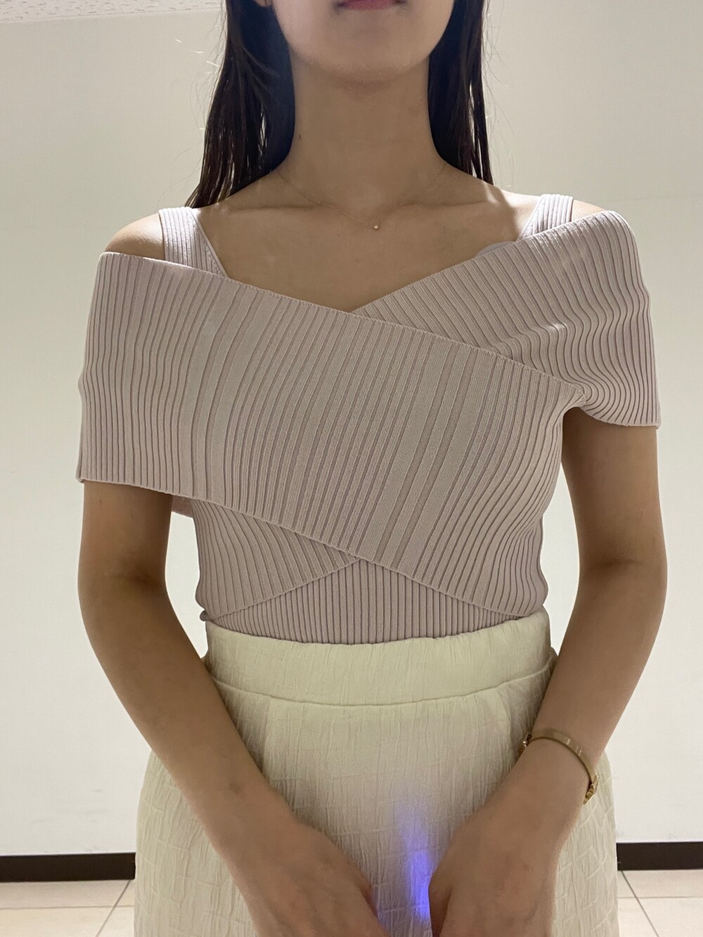 ホワイト系のスカート、ベージュ系のニット/セーター、ブラック系のサンダルを着用したレディースの春コーディネートの6枚目の写真