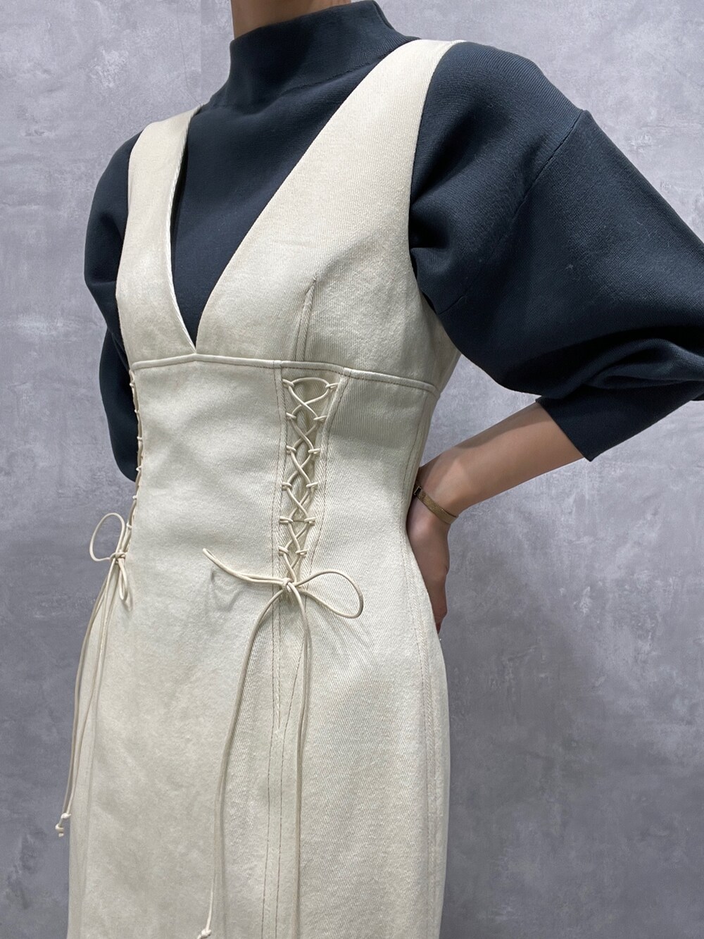 グリーン系のニット/セーター、ホワイト系のカーディガン/ボレロ、ブラック系のブーツを着用したレディースの冬コーディネートの9枚目の写真