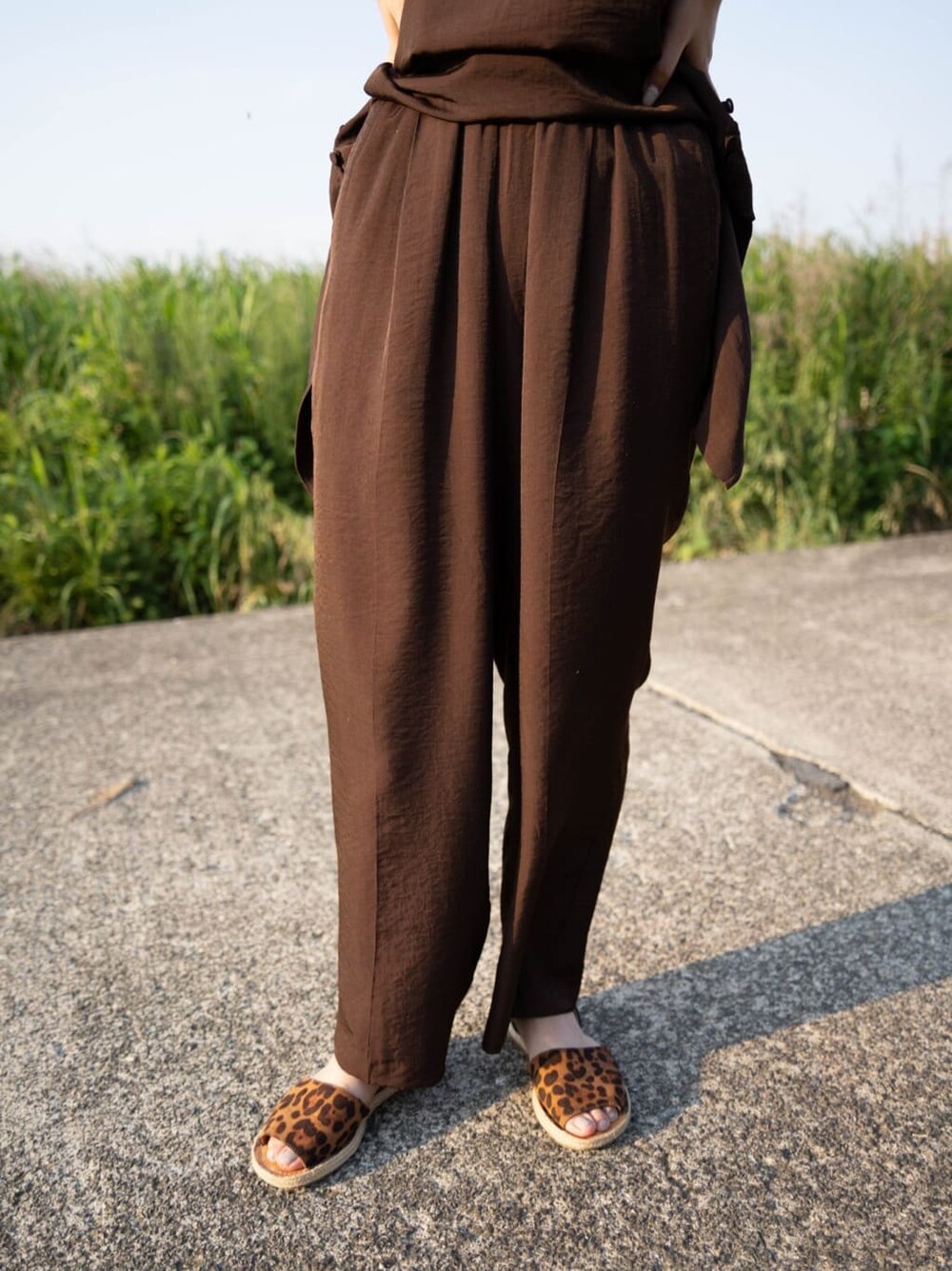 ブラウン系のワンピース、シルバー系のバングル/リストバンドを着用したレディースの夏コーディネートの6枚目の写真