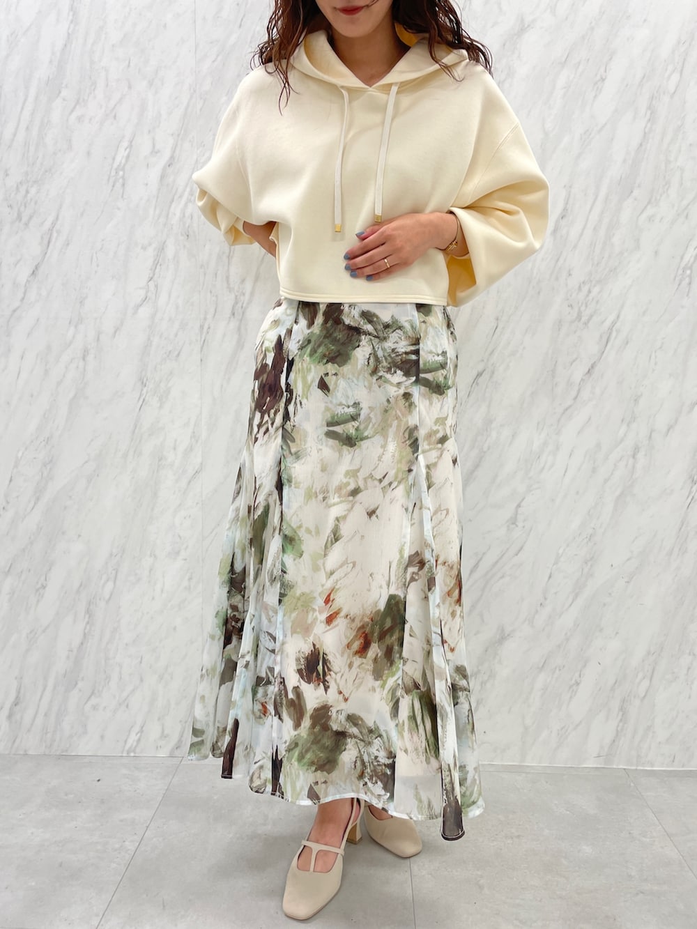 ホワイト系のパンプス、ベージュ系のスカート、ホワイト系のパーカーを着用したレディースの冬コーディネートの8枚目の写真