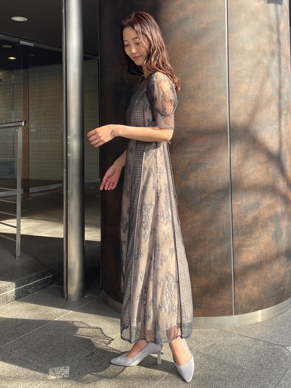 グレー系のドレス、グレー系のパンプス、ホワイト系のトレンチコートを着用したレディースの冬コーディネートの6枚目の写真