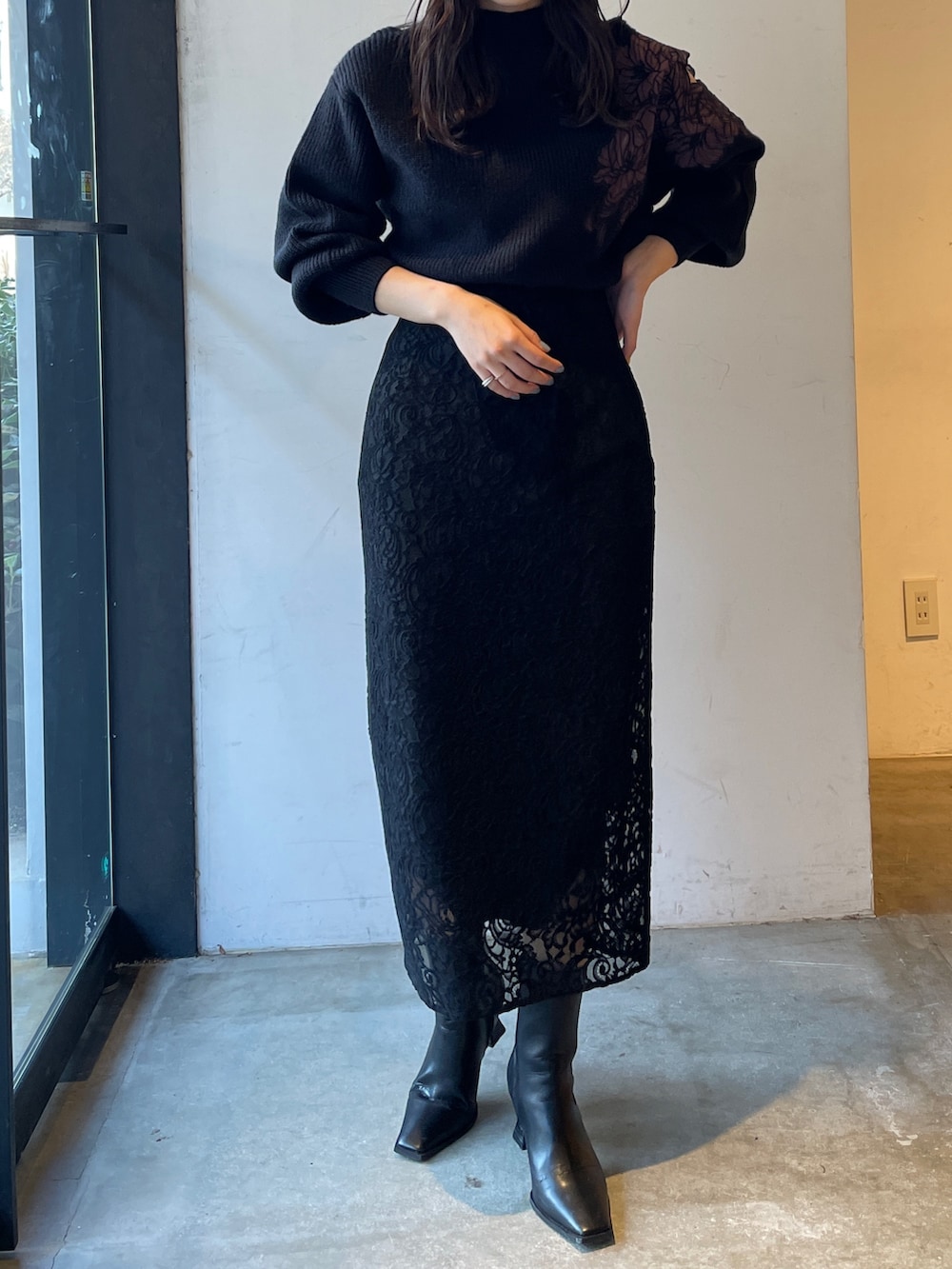 ブラック系のブーツ、ブラック系のスカート、ブラック系のニット/セーターを着用したレディースの冬コーディネートの4枚目の写真