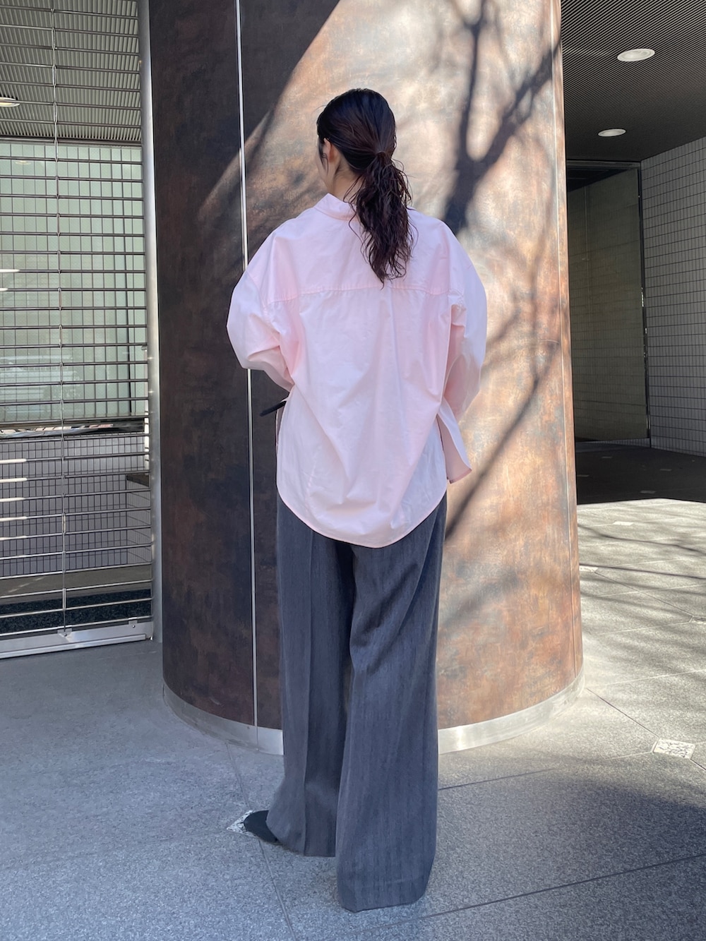 グレー系のその他パンツ、ピンク系のシャツ/ブラウス、ブラック系のパンプスを着用したレディースの冬コーディネートの4枚目の写真