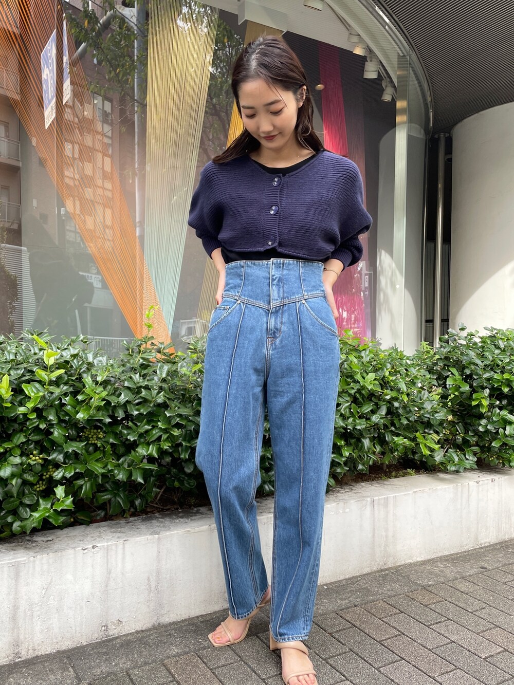 ベージュ系のサンダル、ブルー系のデニムパンツ、ブラック系のニット/セーターを着用したレディースの冬コーディネートの2枚目の写真