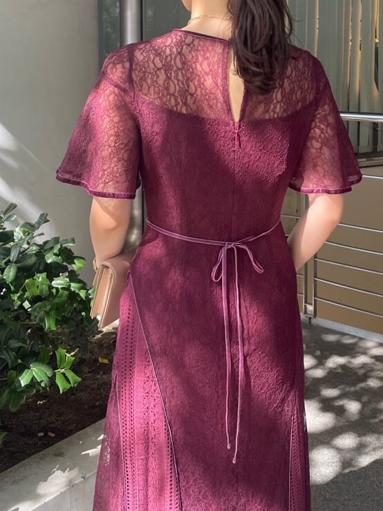 レッド系のドレス、ゴールド系のクラッチバッグ、ゴールド系のパンプスを着用したレディースの秋コーディネートの7枚目の写真