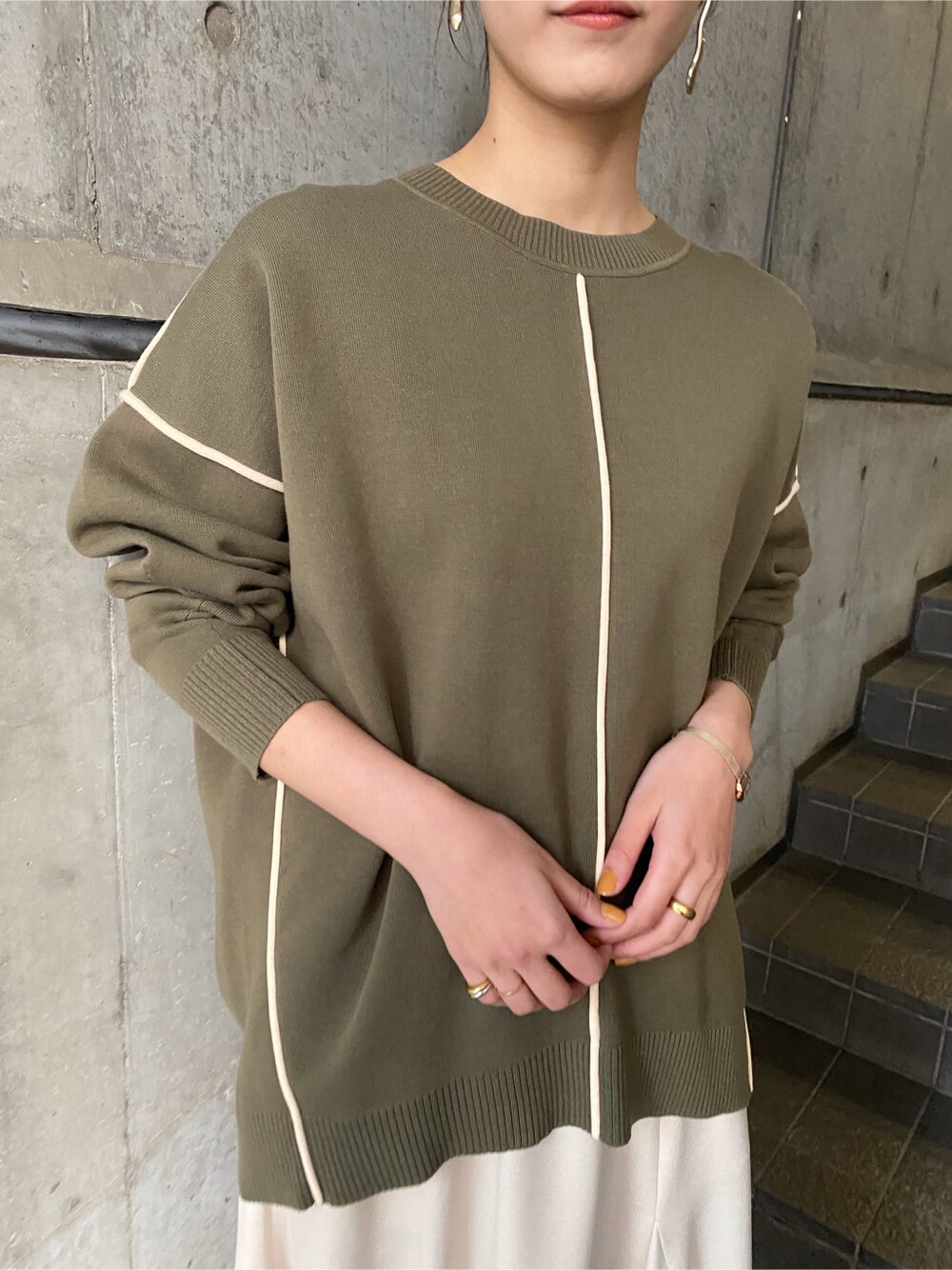 ホワイト系のスカート、ベージュ系のブーツ、ベージュ系のニット/セーターを着用したレディースの冬コーディネートの4枚目の写真