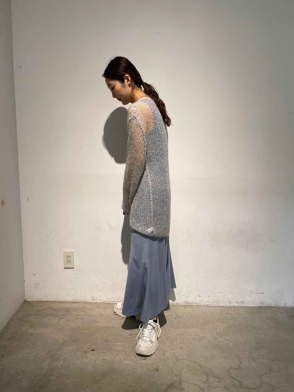 ホワイト系のスニーカー、ブルー系のニット/セーター、ブルー系のワンピースを着用したレディースの春コーディネートの7枚目の写真