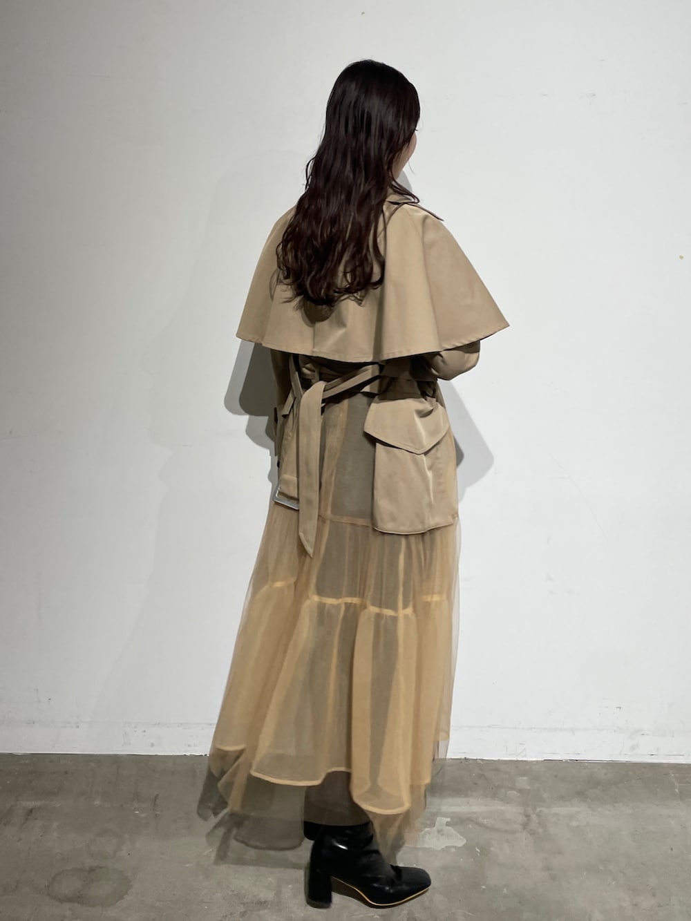 ブラック系のブーツ、グレー系のワンピース、ベージュ系のトレンチコートを着用したレディースの春コーディネートの6枚目の写真