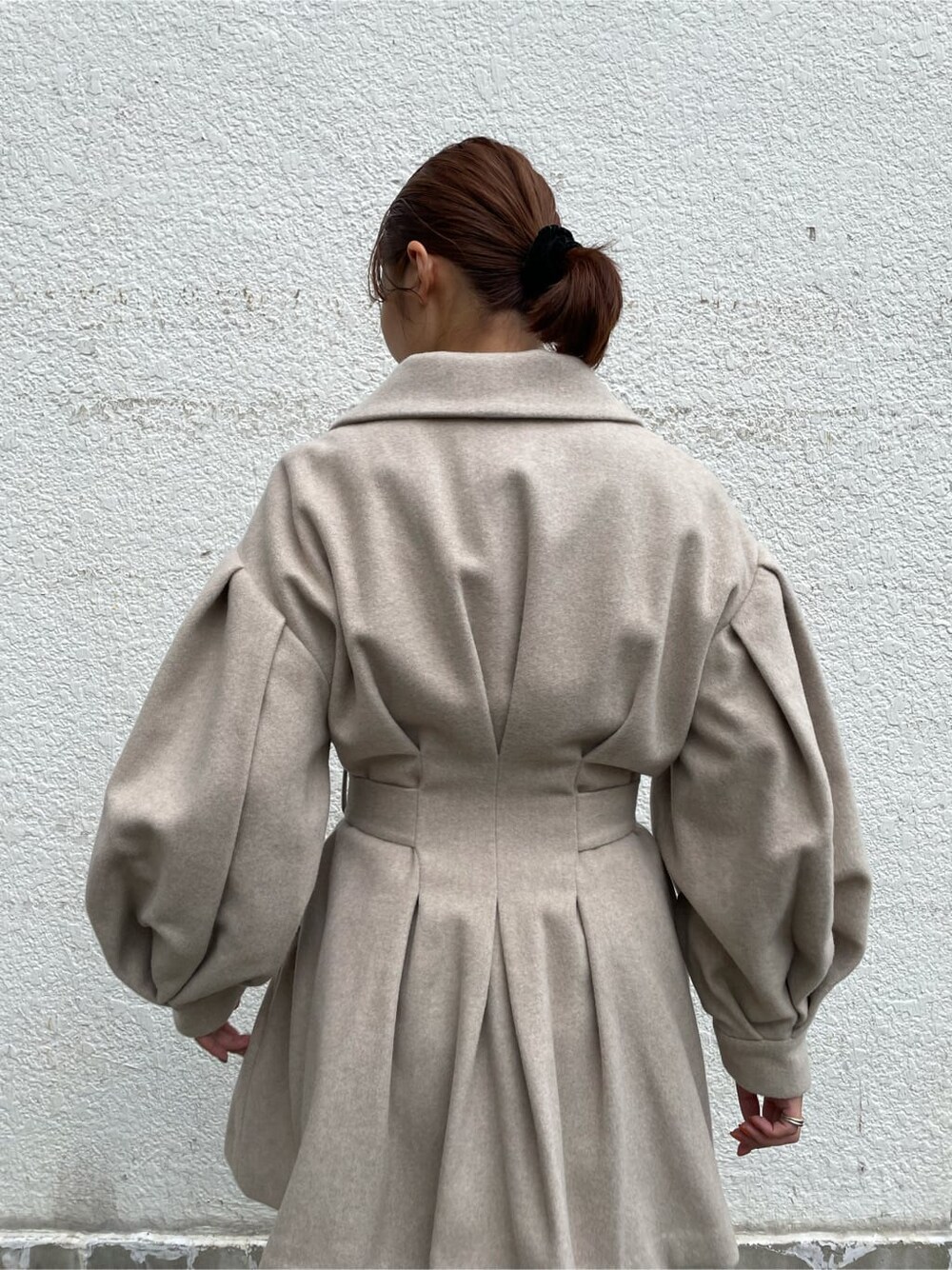 ホワイト系のスカート、ホワイト系のその他シューズ、ベージュ系のその他アウターを着用したレディースの秋コーディネートの4枚目の写真