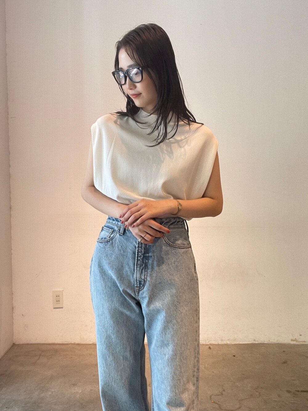 ブルー系のデニムパンツ、ホワイト系のニット/セーター、イエロー系のサンダルを着用したレディースの夏コーディネートの4枚目の写真