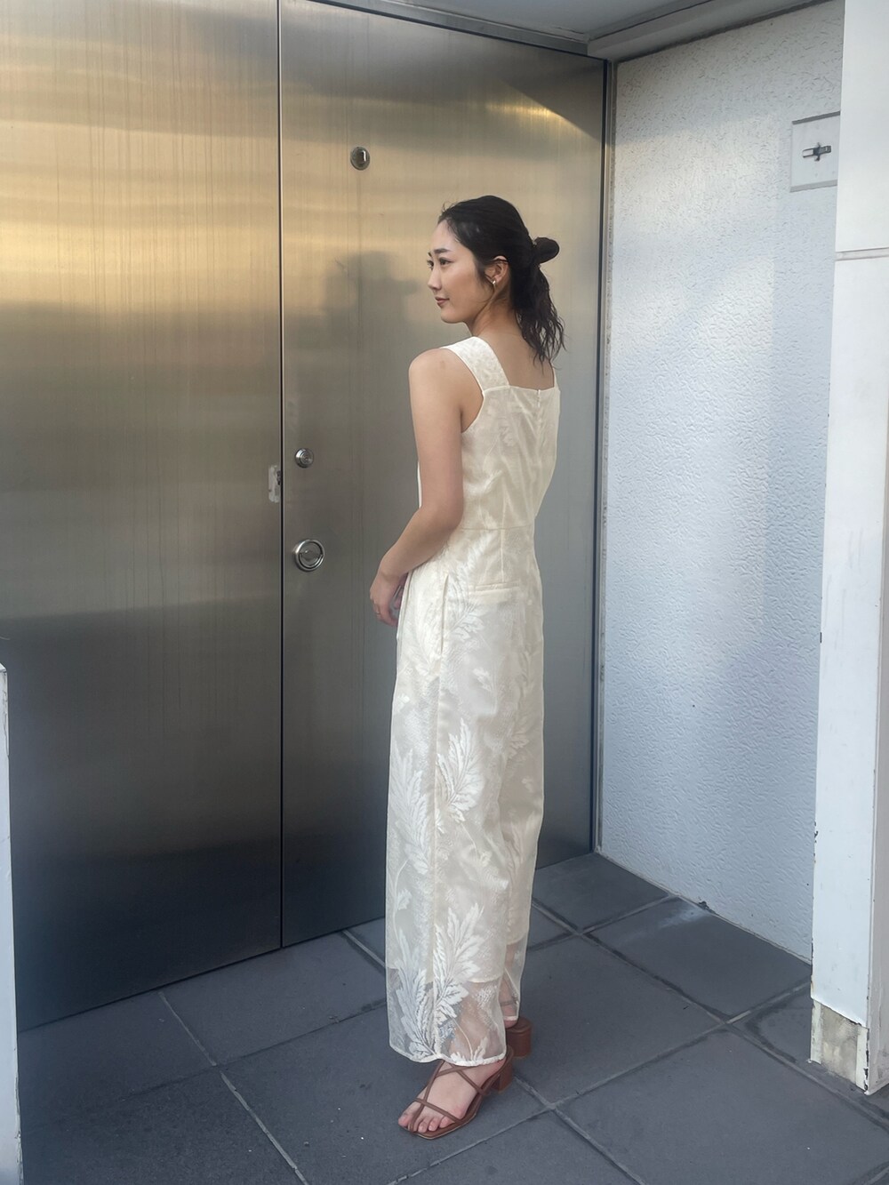 ブラウン系のサンダル、ホワイト系のつなぎ/オールインワン、ベージュ系の折りたたみ傘を着用したレディースの冬コーディネートの5枚目の写真