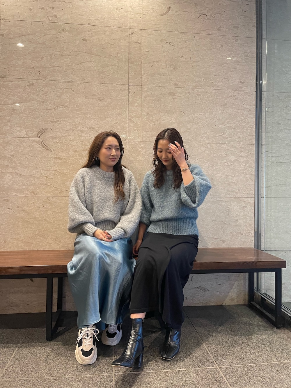 グリーン系のニット/セーター、ブラック系のブーツ、ブラック系のスカートを着用したレディースの冬コーディネートの2枚目の写真