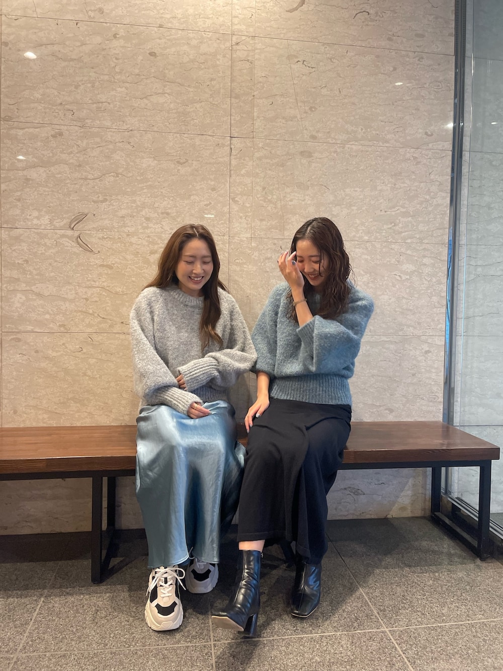 グリーン系のニット/セーター、ブラック系のブーツ、ブラック系のスカートを着用したレディースの冬コーディネートの3枚目の写真