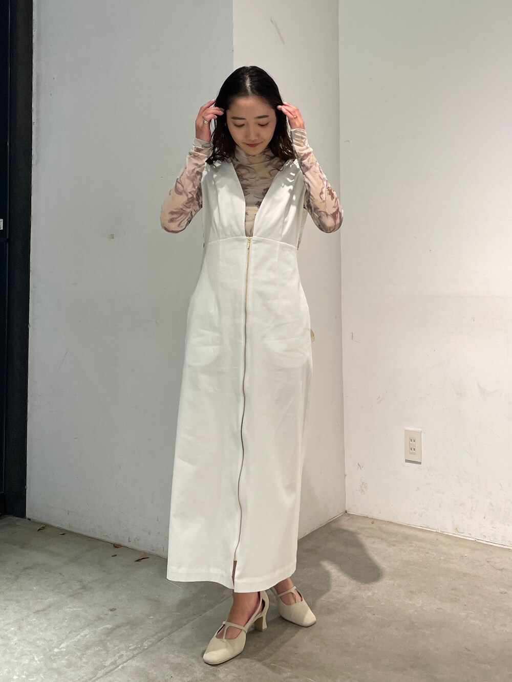 ホワイト系のパンプス、イエロー系のTシャツ/カットソー、ホワイト系のジャンパースカートを着用したレディースの冬コーディネートの4枚目の写真