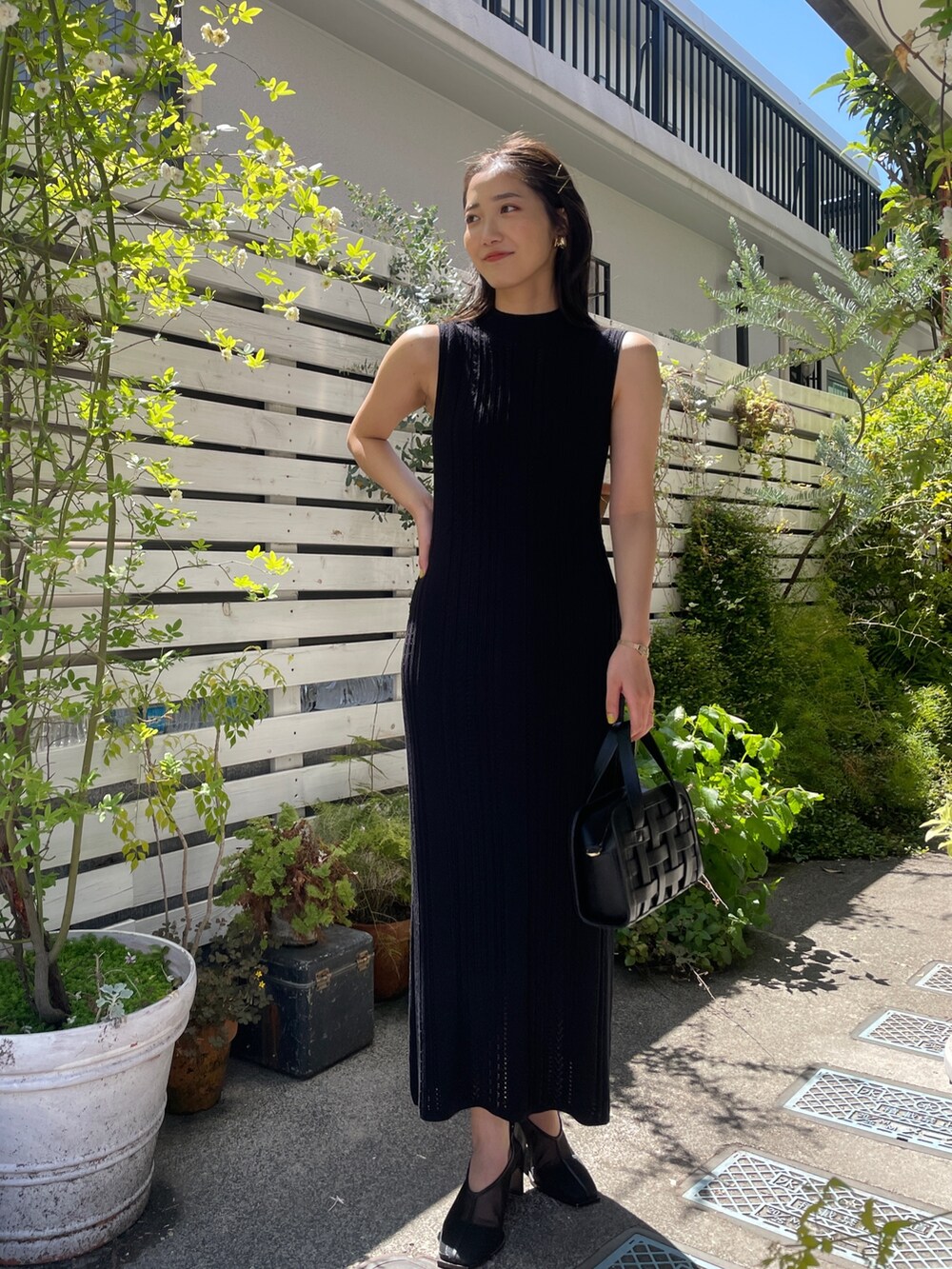 ブラック系のショルダーバッグ、ブラック系のワンピース、ベージュ系のテーラードジャケットを着用したレディースの春コーディネートの5枚目の写真