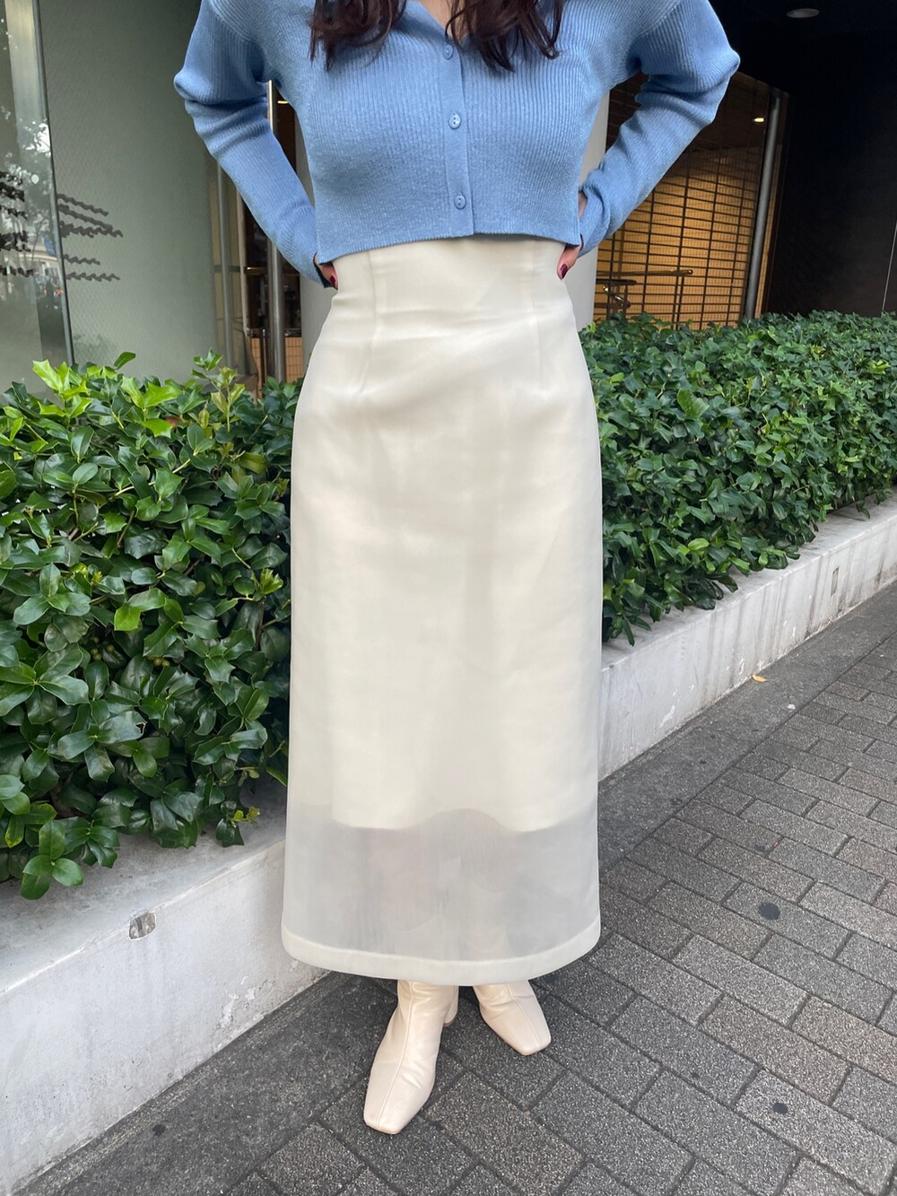 ホワイト系のブーツ、ホワイト系のスカート、ブルー系のカーディガン/ボレロを着用したレディースの秋コーディネートの7枚目の写真