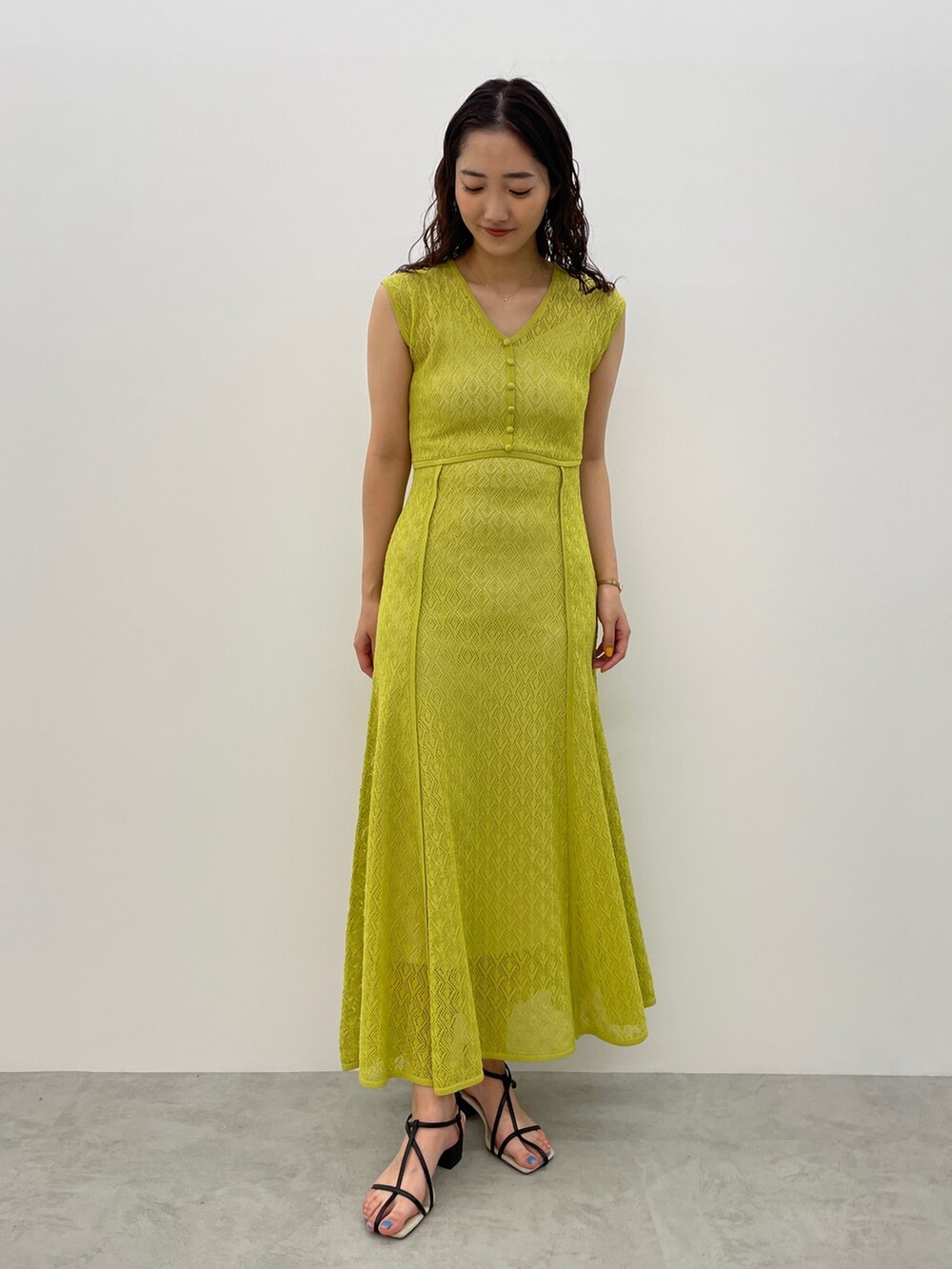 ブラック系のサンダル、グリーン系のワンピースを着用したレディースの春コーディネートの2枚目の写真