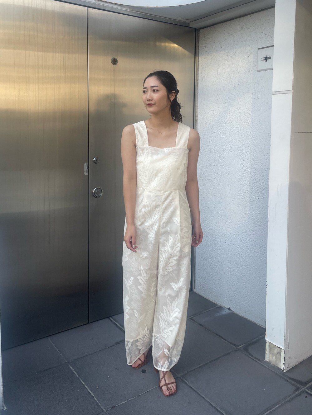 ブラウン系のサンダル、ホワイト系のつなぎ/オールインワン、ベージュ系の折りたたみ傘を着用したレディースの冬コーディネートの3枚目の写真