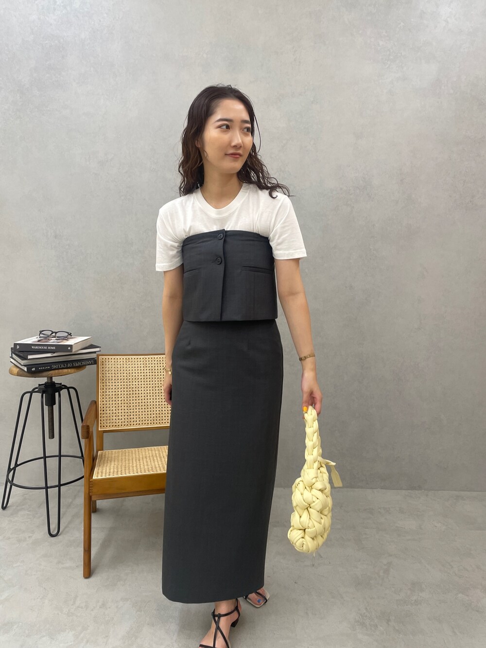 グレー系のスカート、ホワイト系のTシャツ/カットソー、ベージュ系のハンドバッグを着用したレディースの春コーディネートの4枚目の写真