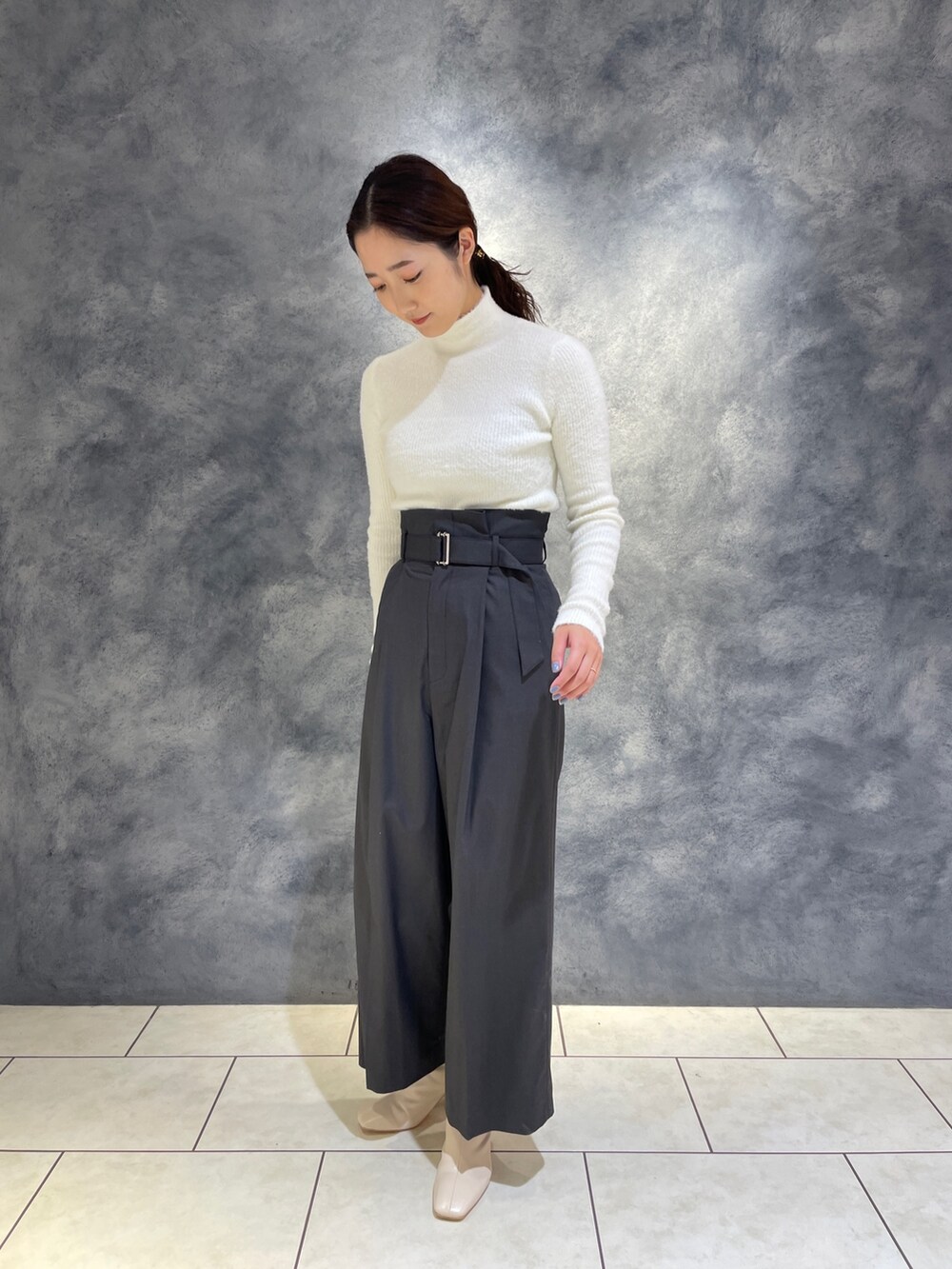 グレー系のその他パンツ、ホワイト系のニット/セーター、ホワイト系のブーツを着用したレディースの冬コーディネートの5枚目の写真