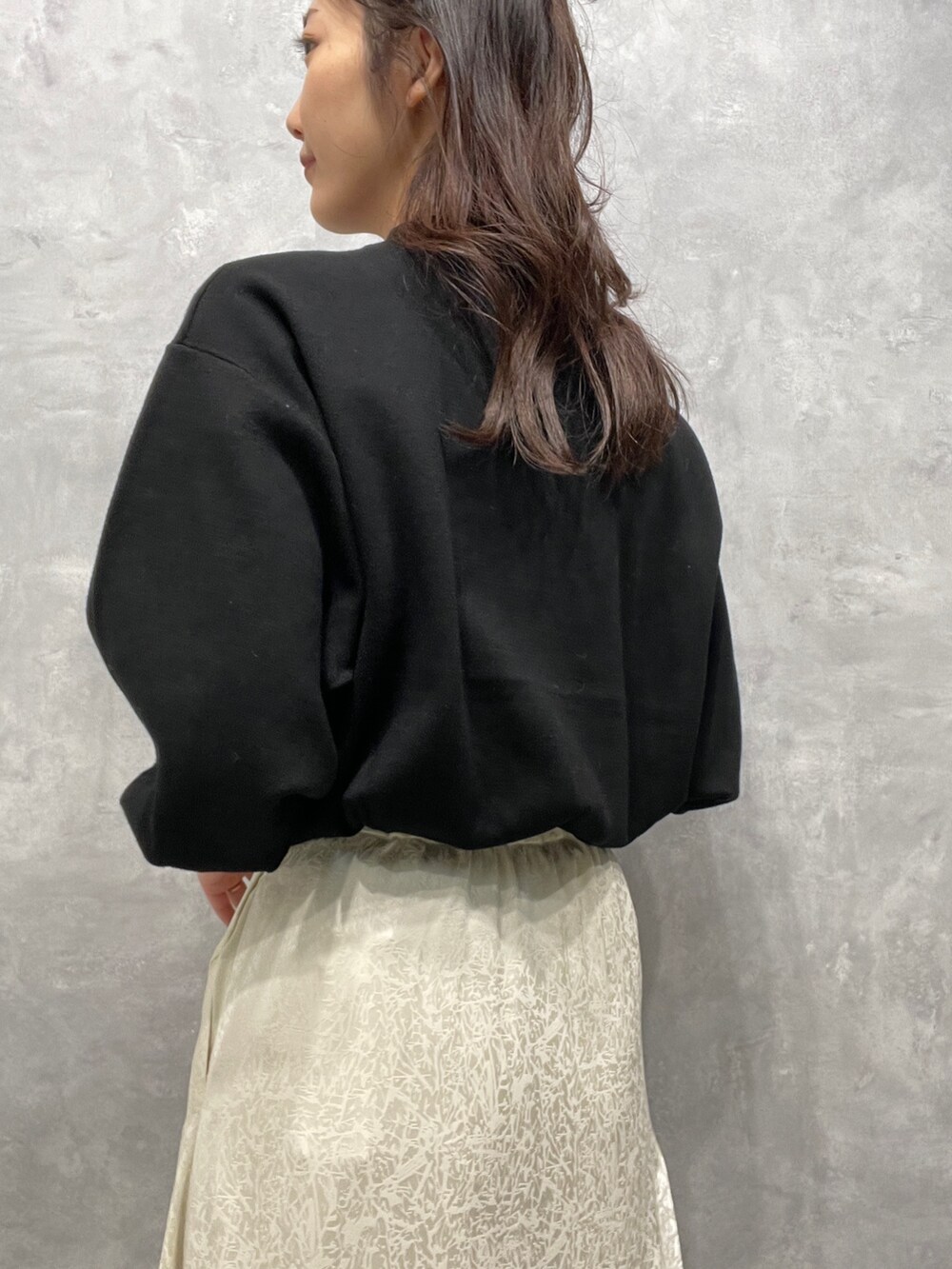 ブラック系のニット/セーター、ホワイト系のスカート、ベージュ系のブーツを着用したレディースの冬コーディネートの9枚目の写真