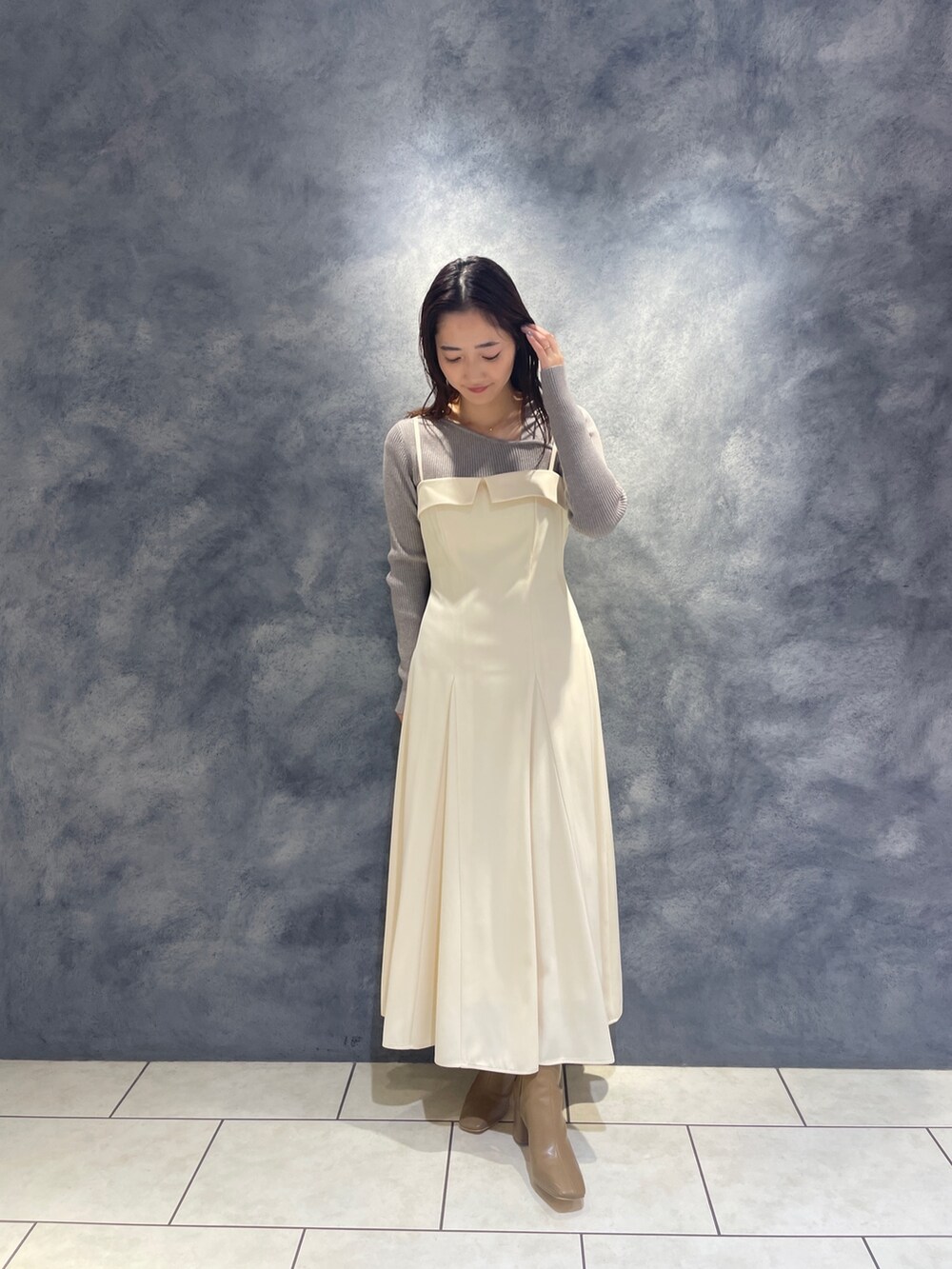 ベージュ系のブーツ、グレー系のニット/セーター、ホワイト系のワンピースを着用したレディースの秋コーディネートの4枚目の写真