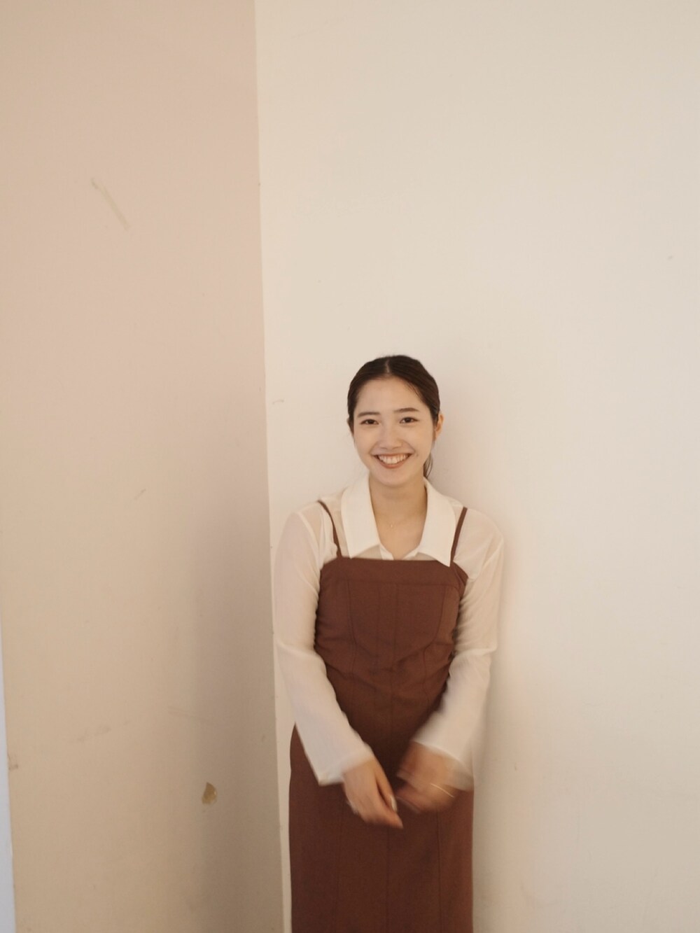 グレー系のステンカラーコート、ブラウン系のワンピースを着用したレディースの秋コーディネートの9枚目の写真