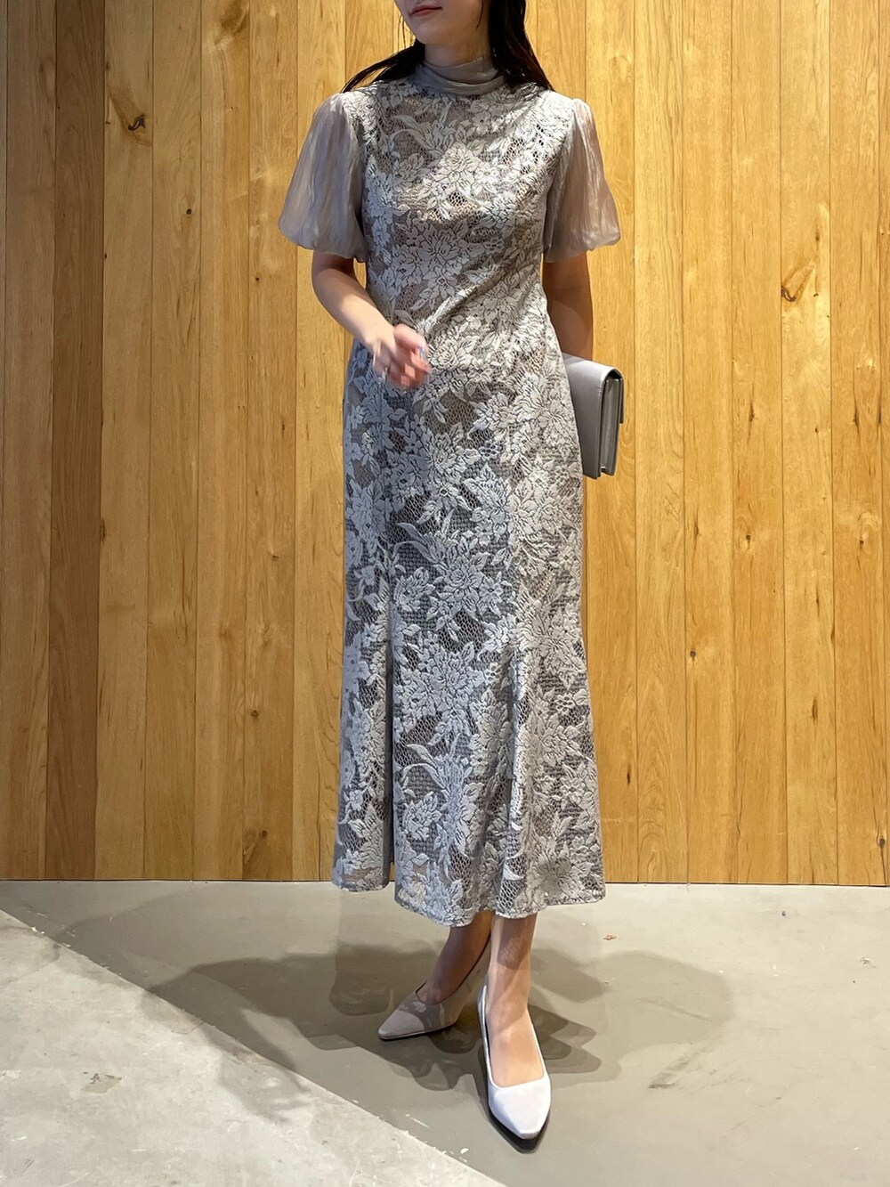 グレー系のパンプス、グレー系のクラッチバッグ、グレー系のドレスを着用したレディースの冬コーディネートの3枚目の写真