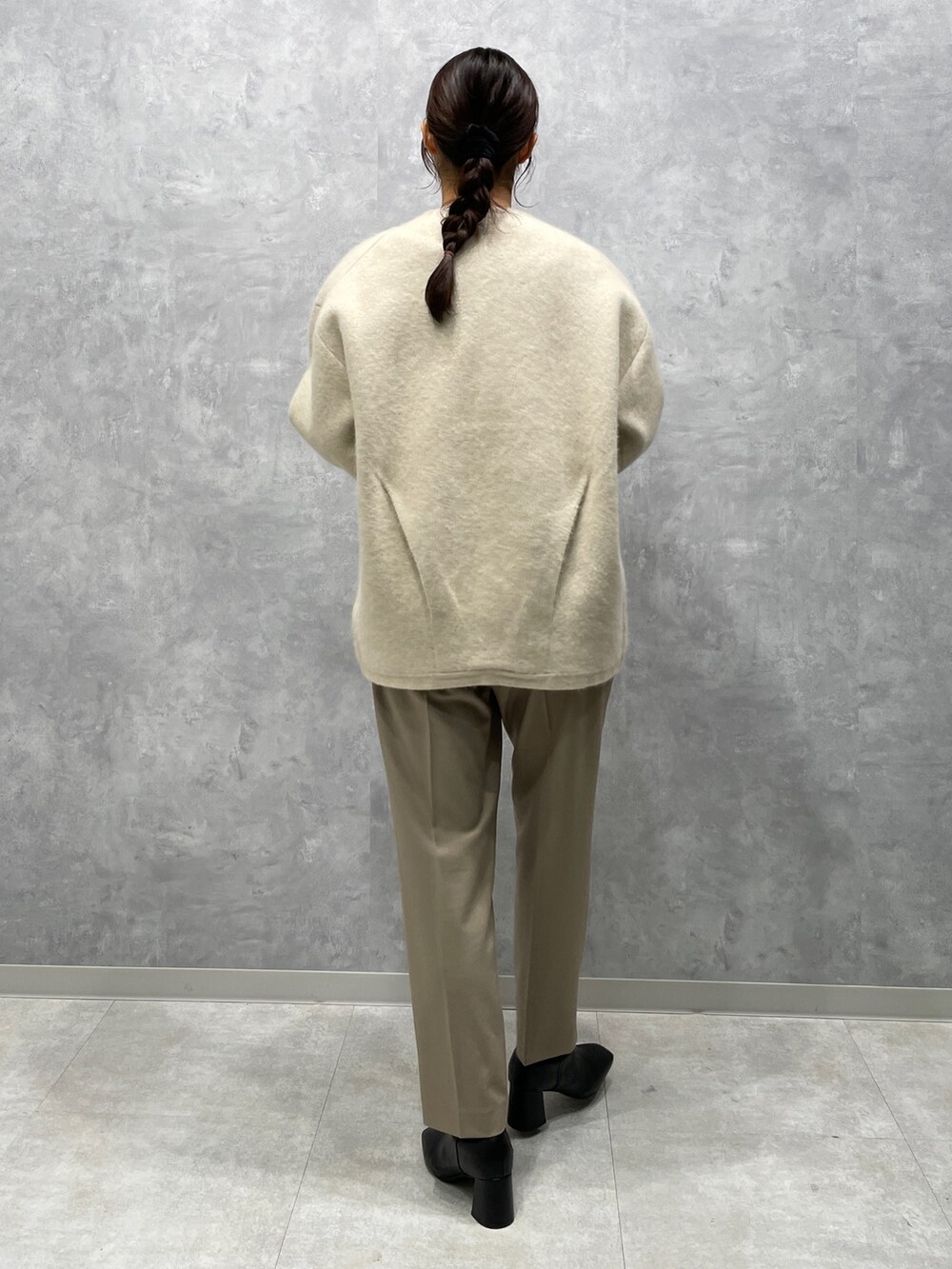 ホワイト系のカーディガン/ボレロ、ブラック系のブーツ、ホワイト系のシャツ/ブラウスを着用したレディースの冬コーディネートの3枚目の写真