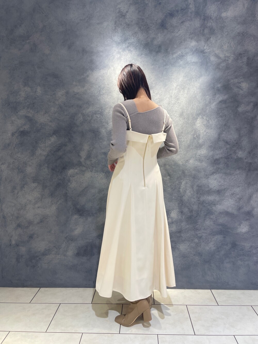 ベージュ系のブーツ、グレー系のニット/セーター、ホワイト系のワンピースを着用したレディースの秋コーディネートの5枚目の写真