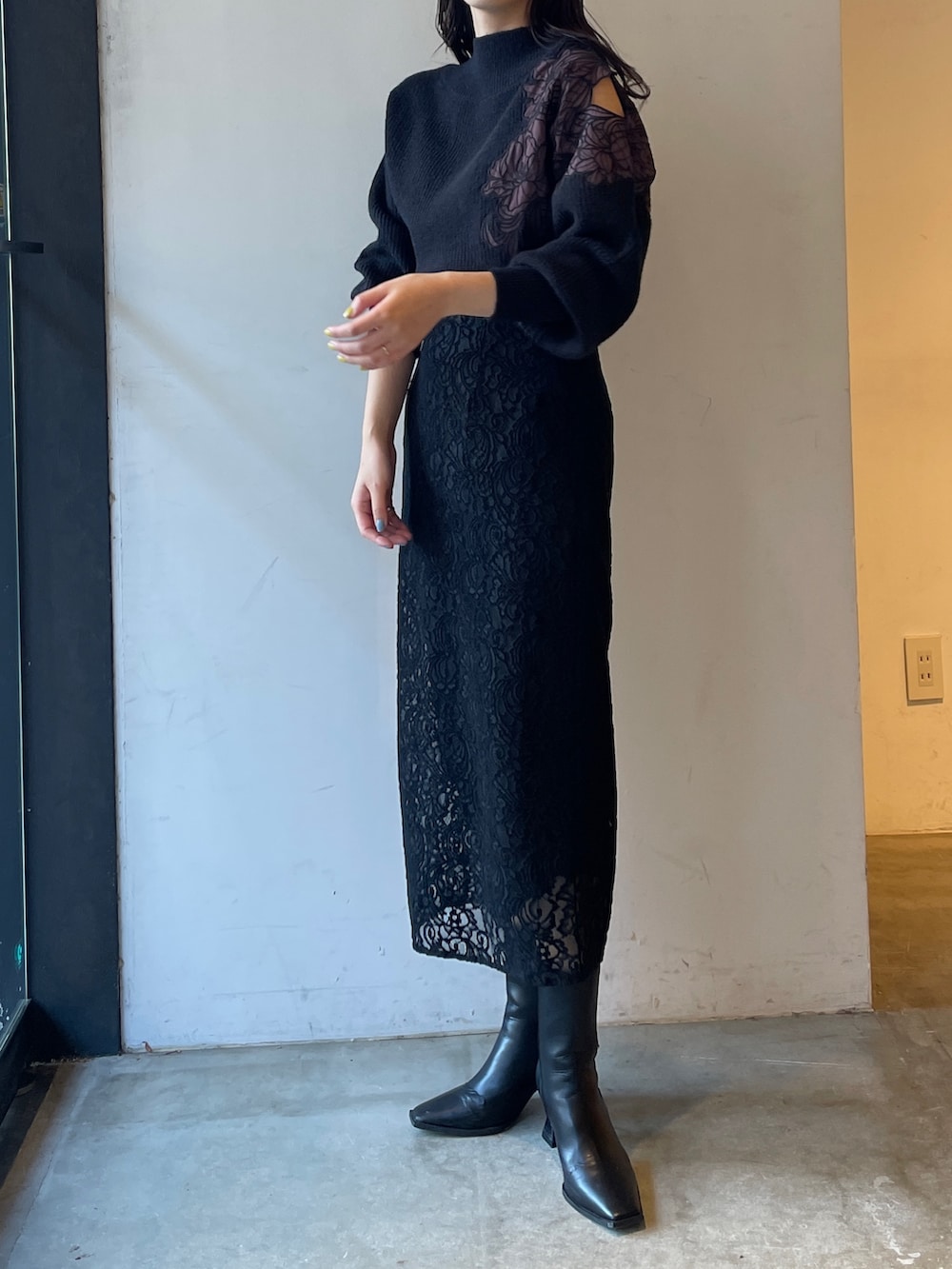 ブラック系のブーツ、ブラック系のスカート、ブラック系のニット/セーターを着用したレディースの冬コーディネートの3枚目の写真